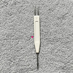A Silver Reed chunky electronic knitting machine 1x2 stitch transfer tool, with a white handle and two metal tips