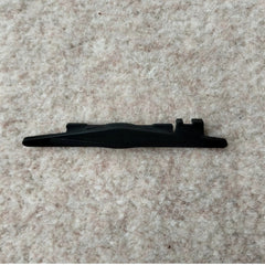 A black plastic row counter trip cam for a Passap Duomatic 80 knitting machine, placed on a beige carpet background.
