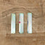 A set of three metal wide claw weights for a Silver Reed LC 580 electronic lace carriage, displayed on a wooden surface.