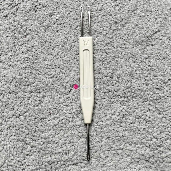 A Silver Reed chunky electronic knitting machine 1x2 stitch transfer tool, with a white handle and two metal tips