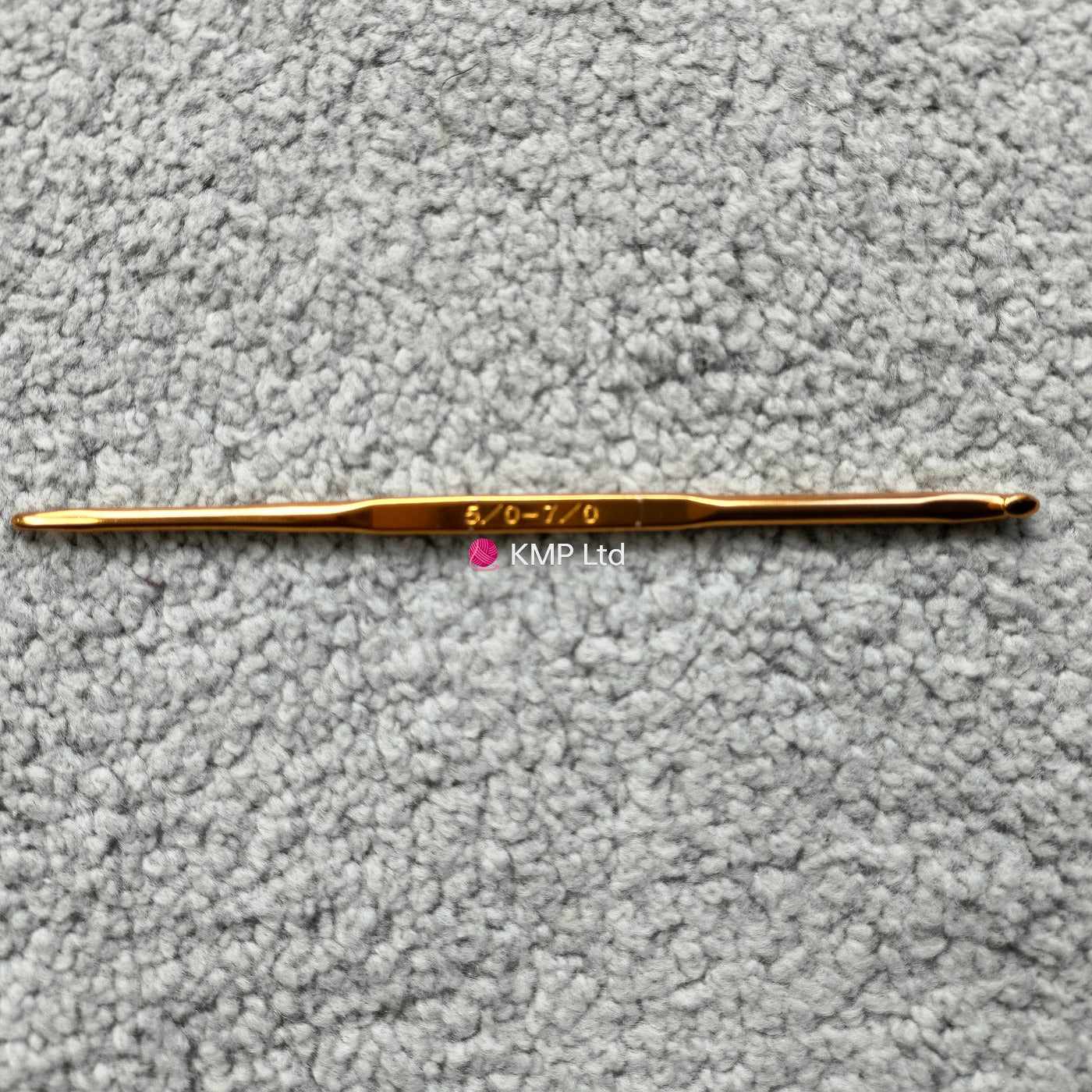 silver reed sk 890 chunky electronic-knitting machine crochet hook with '5-6' and '07' engraved on it, placed on a grey textured surface.