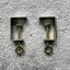 Silver Reed SK 890 Brass-colored table clamps for an electronic knitting machine, placed on a grey background.