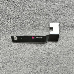A metal carriage lock for an electronic knitting machine, with a branded name 'Knitting Machine Co Ltd'.