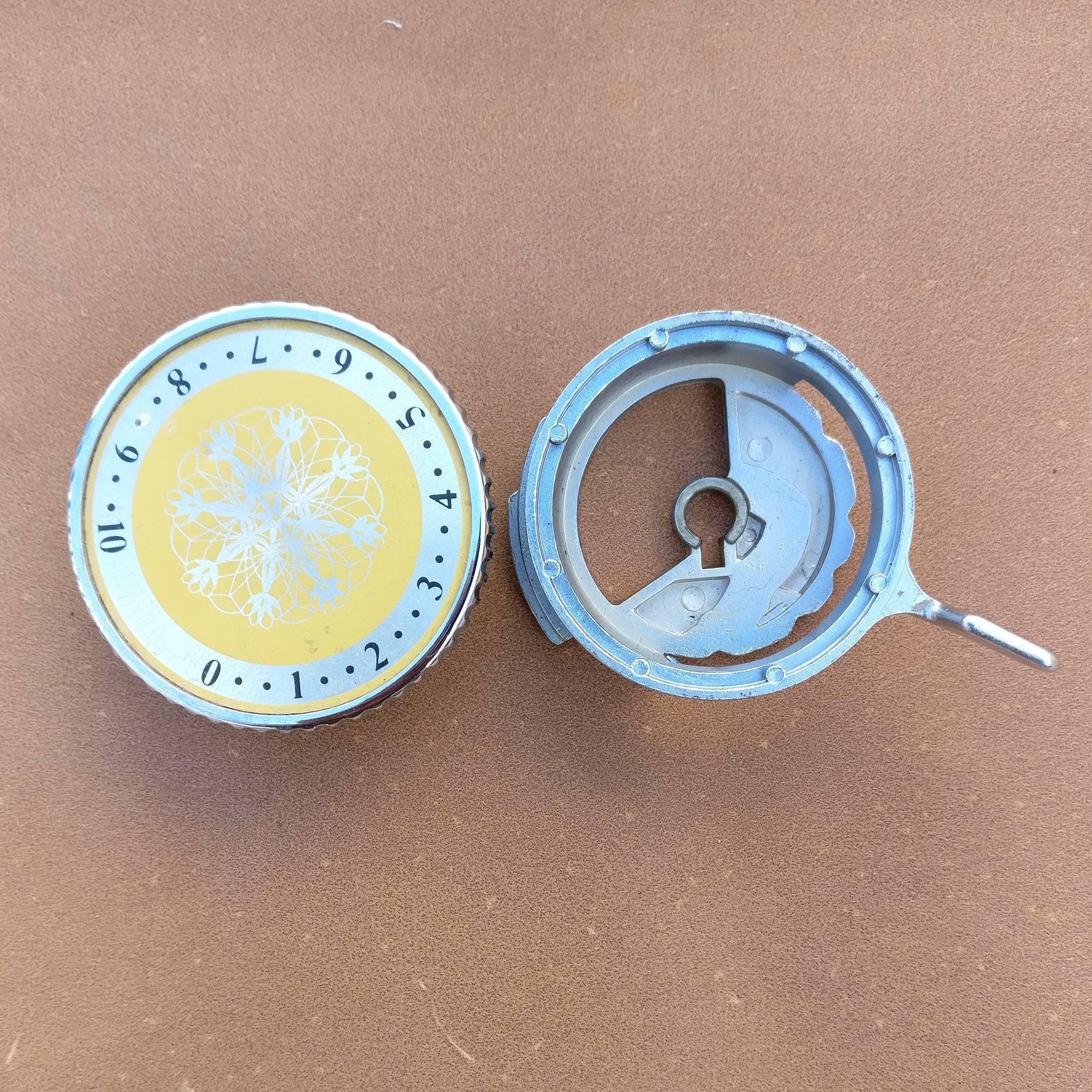A Knitmaster Mod 321 Knitting Machine Carriage TENSION CAM SET, featuring a yellow and gray color scheme, mechanical components, and a key. Main image